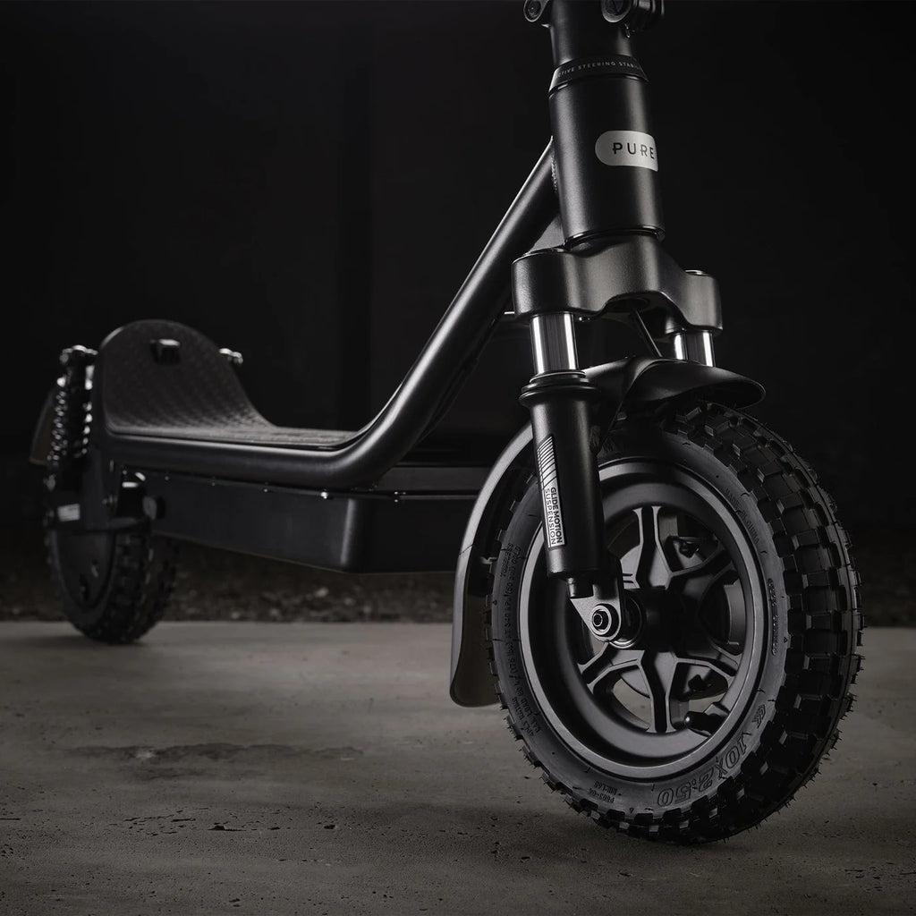 Black electric scooter on a dark background